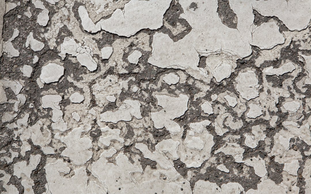 A badly damaged concrete garage floor requiring shotblasting