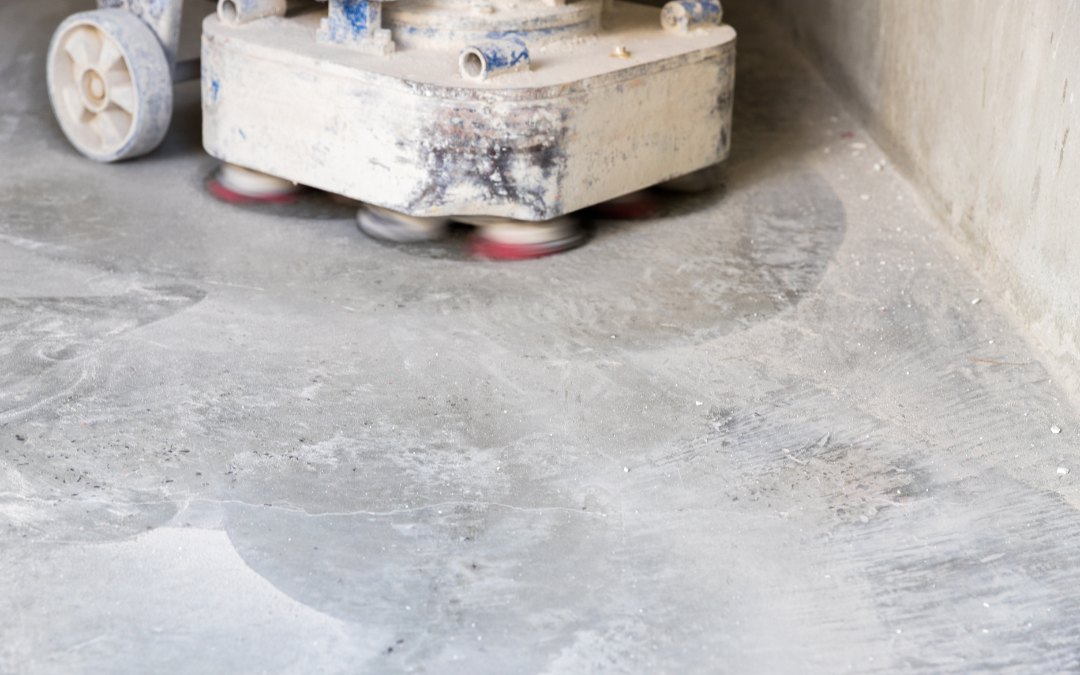 DIY home renovator using a concrete grinder on a garage floor