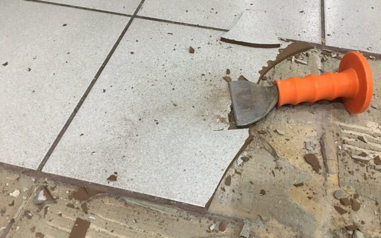 Home DIYer preparing concrete floor before tiling using basic tools